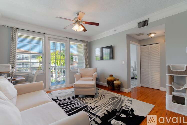 A living room with a white couch and a ceiling fan.