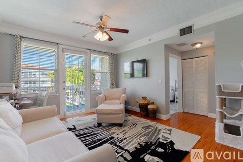 A living room with a white couch and a ceiling fan.