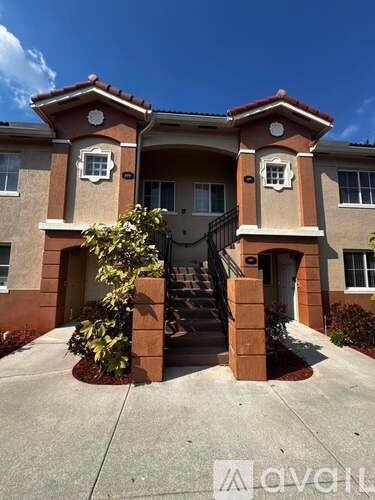 A two-story house with a staircase leading to the front door.