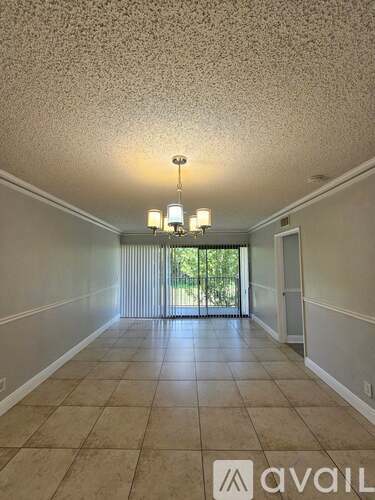 A room with a tiled floor and a chandelier hanging from the ceiling.