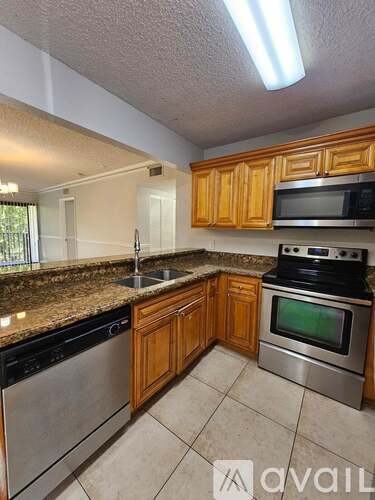 A kitchen with wooden cabinets and granite countertops.