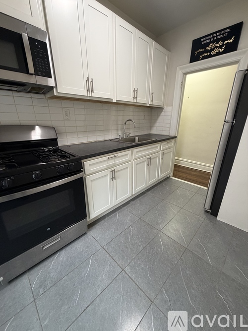 A kitchen with white cabinets and a black stove top oven.