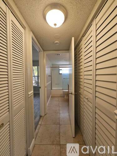 A long hallway with white walls and a tiled floor.