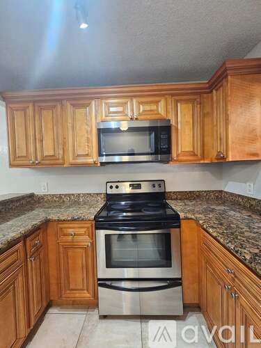 A kitchen with wooden cabinets and a granite countertop.