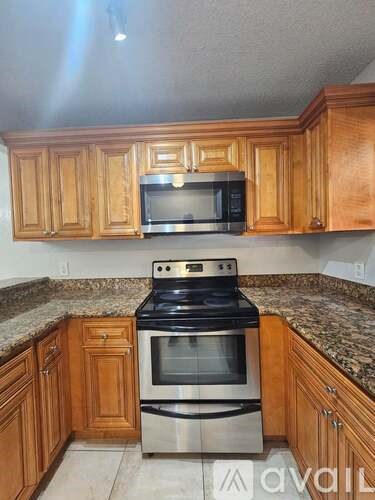 A kitchen with wooden cabinets and a granite countertop.