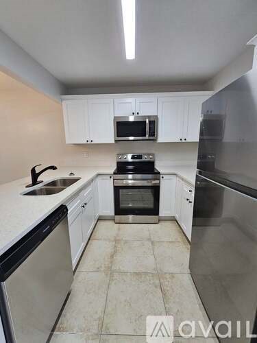 A kitchen with white cabinets and stainless steel appliances.