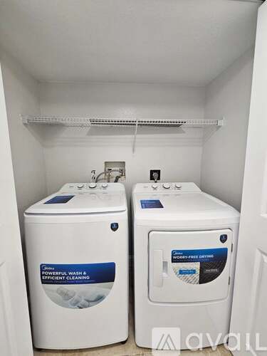 Two front loading washing machines in a small laundry room.