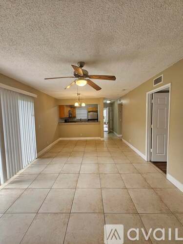 A spacious room with a ceiling fan and tiled flooring.