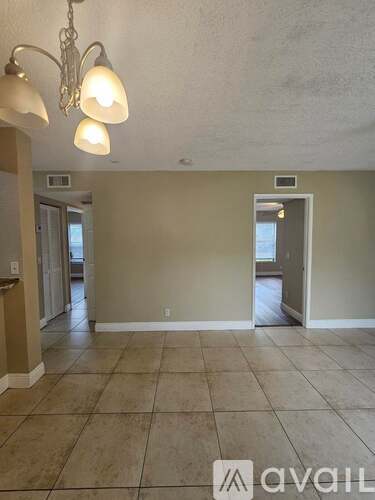 A room with tiled flooring and a chandelier.