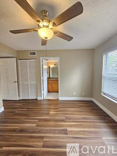 A room with wooden floors and a ceiling fan.