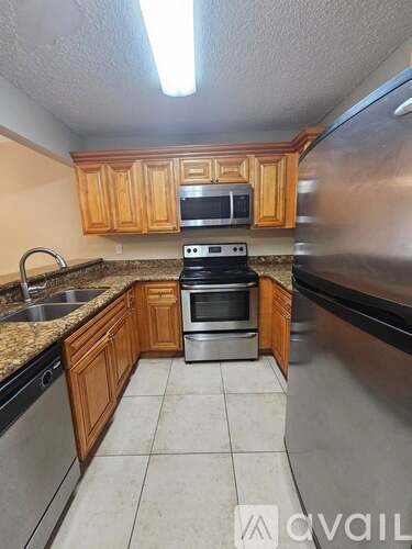 A kitchen with wooden cabinets and stainless steel appliances.