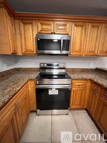 A kitchen with wooden cabinets and a granite countertop.
