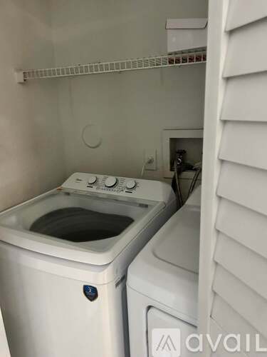 A white washing machine and dryer in a small laundry room.