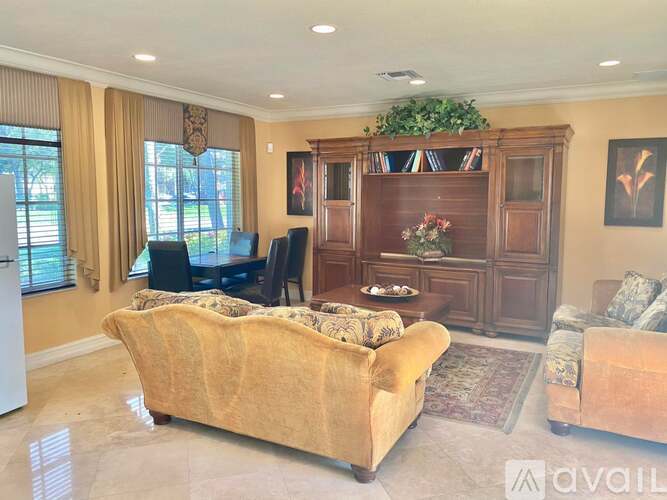 A living room with a sofa, a chair, a coffee table, and a bookshelf.