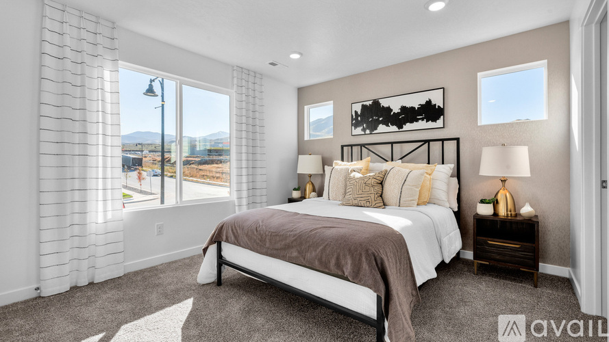 A bedroom with a large bed and a view of the beach through the window.