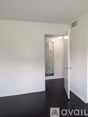 A room with a door and a mirror on the wall.