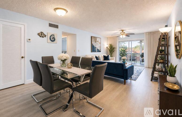 A modern dining room with a glass table and chairs.