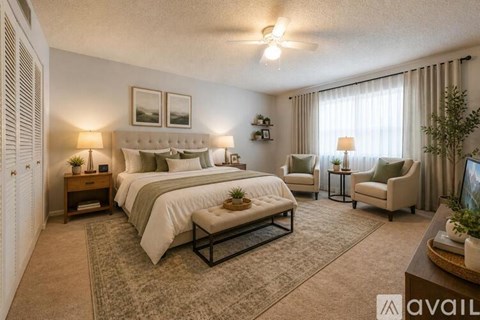 A well-lit bedroom with a large bed and a seating area.