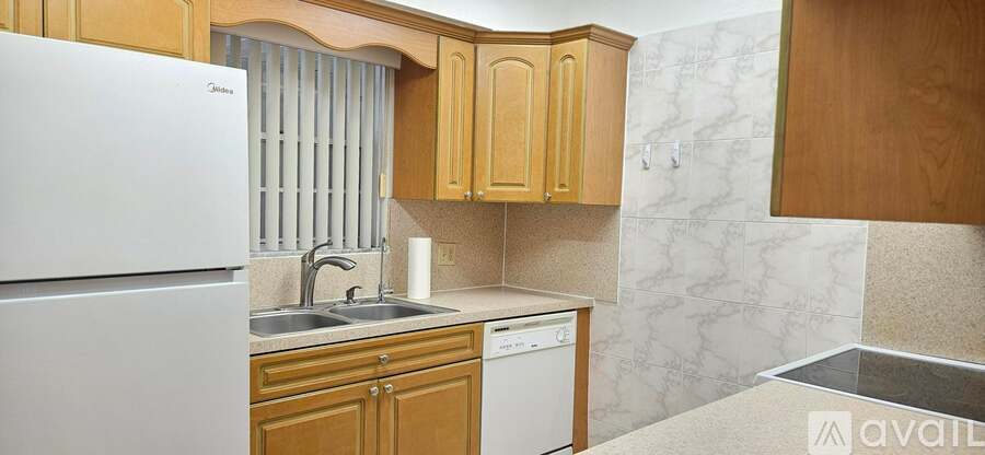 A kitchen with wooden cabinets and a white fridge.