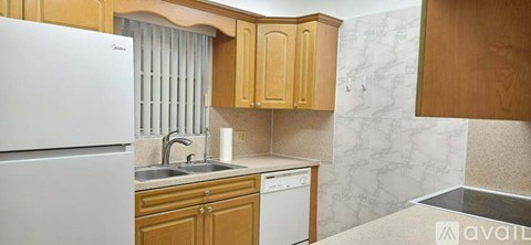 A kitchen with wooden cabinets and a white fridge.