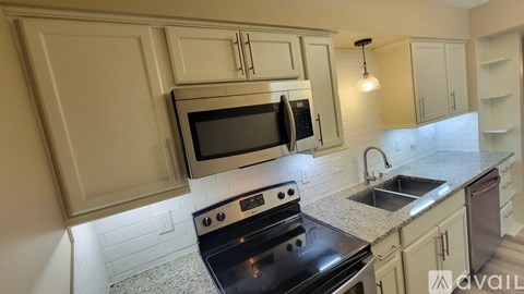 A kitchen with a black stove top oven and a black microwave above it.