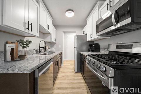 A modern kitchen with a stainless steel oven and white cabinets.