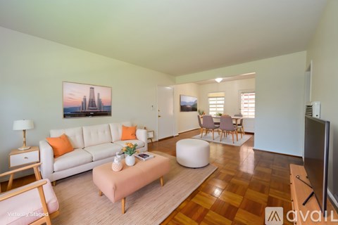 A living room with a white couch, a coffee table, and a painting on the wall.