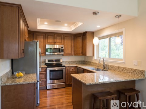 A kitchen with wooden cabinets and granite countertops.