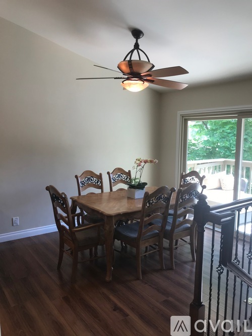 A dining room with a table and chairs.