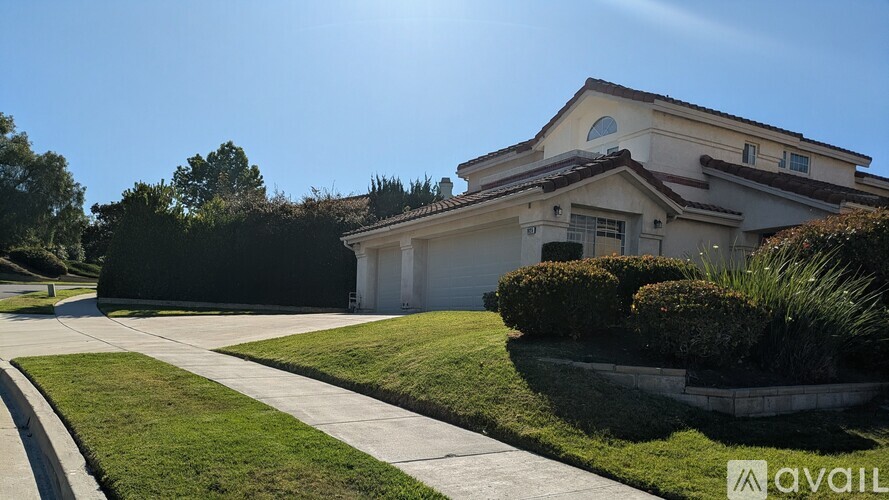 A house with a well-maintained lawn and a clear sky.