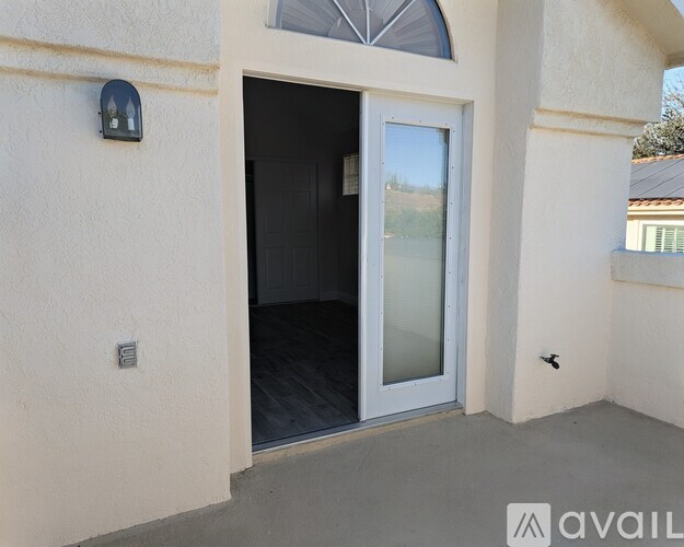 A modern house entrance with a glass door and a small window above it.