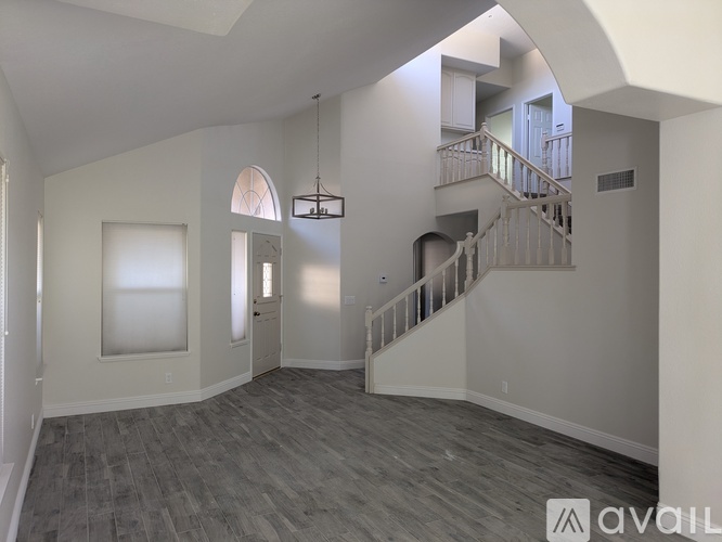 A spacious living room with a staircase leading to the upper floor.