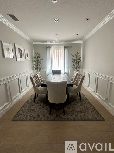 A dining room with a table and chairs.