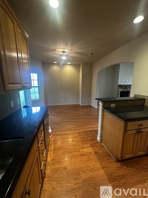 A kitchen with wooden cabinets and black countertops.
