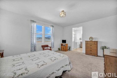 A bedroom with a large bed and a window with a view of the ocean.