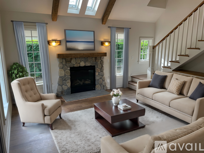 A living room with a fireplace and a painting above it.