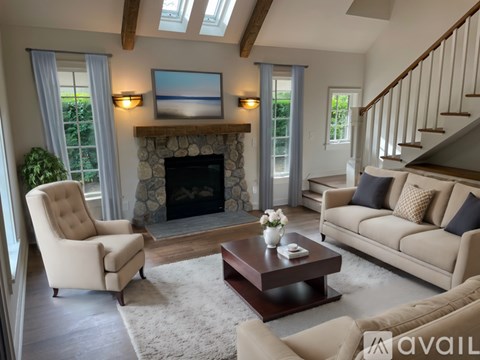 A living room with a fireplace and a painting above it.