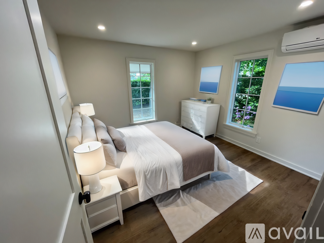 A bedroom with a large bed and a window overlooking the ocean.