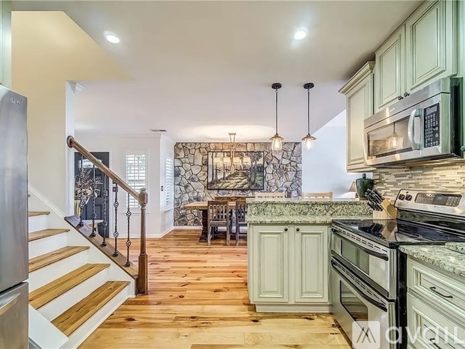 A kitchen with green cabinets and a wooden floor.