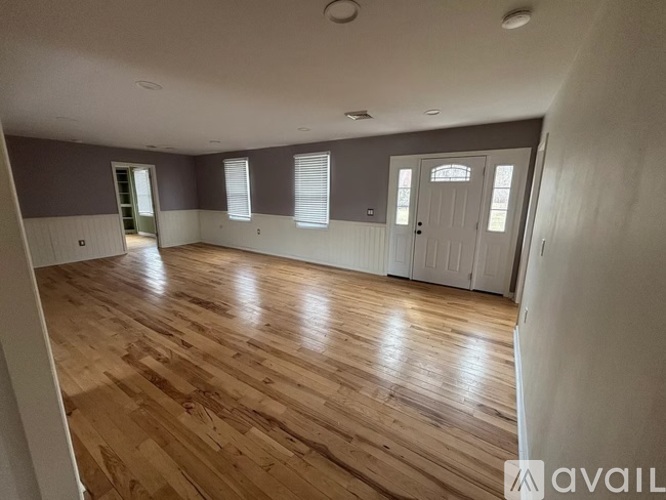 A room with wooden flooring and white walls.