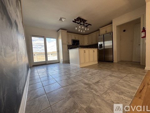 A kitchen with tile flooring and a dining area with a table and chairs.