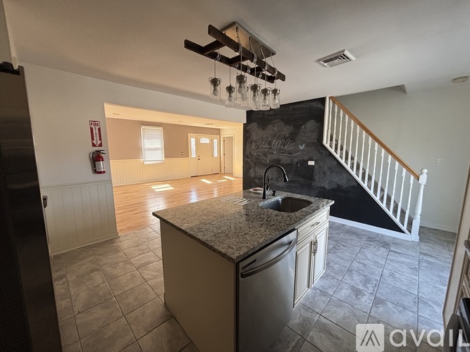 A kitchen with a granite countertop and a stainless steel dishwasher.