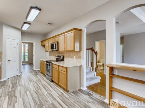 A kitchen with wooden cabinets and a stainless steel refrigerator.