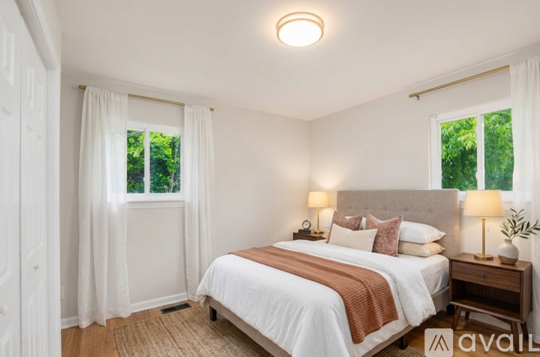 A bedroom with a large bed and two lamps.