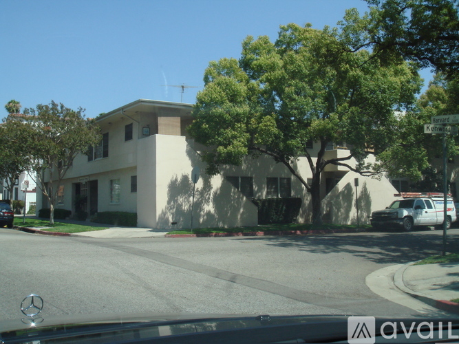 A Mercedes car is parked on the street in front of a house.