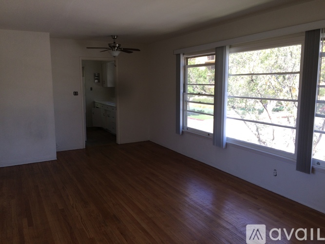 A room with wooden floors and a ceiling fan.
