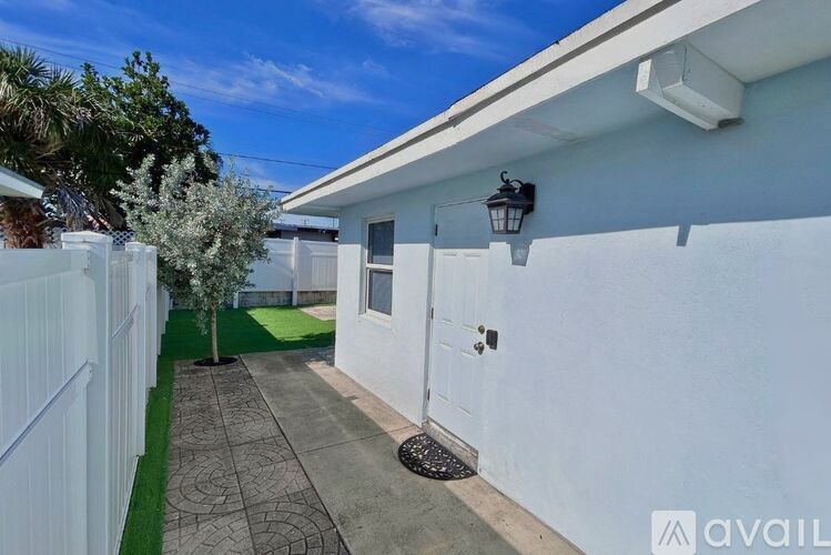 A white house with a white fence and a white door.