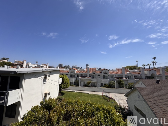 A sunny day in a residential area with houses and clear skies.