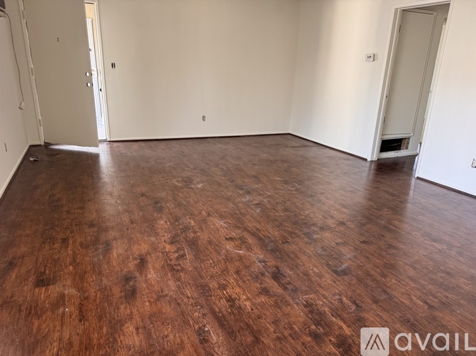 A room with wooden flooring and two doors.