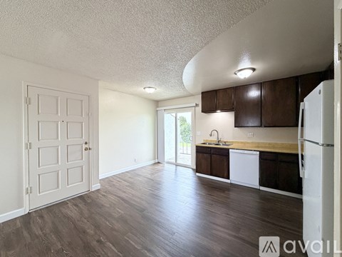 A kitchen with white cabinets and a white refrigerator.